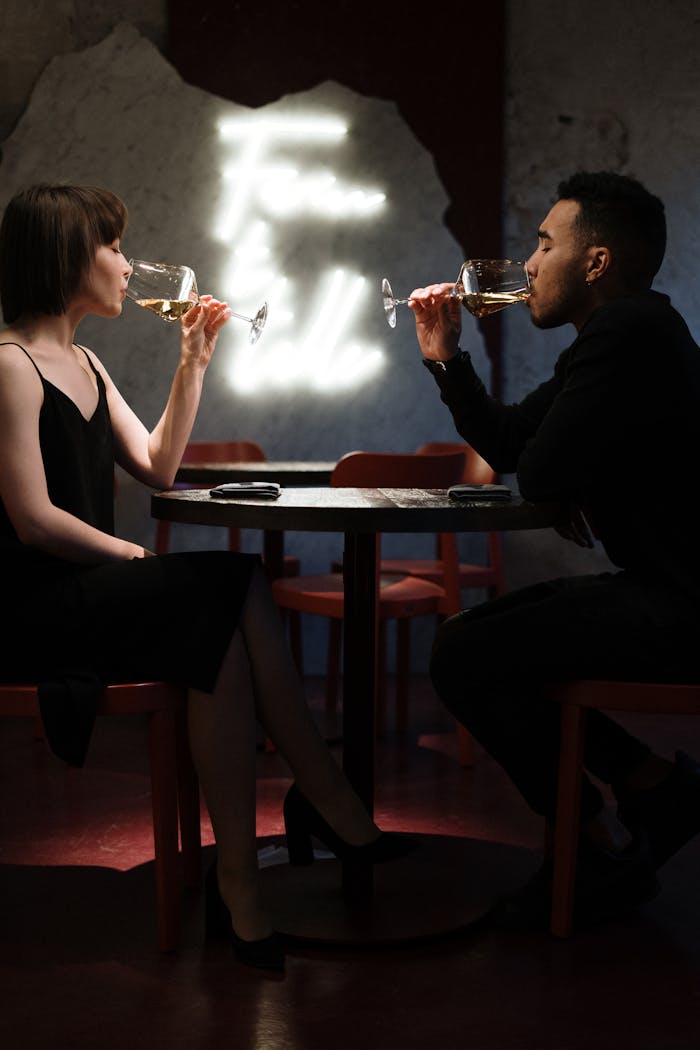 about-01 A couple enjoys a romantic evening sipping white wine at a stylish bar.