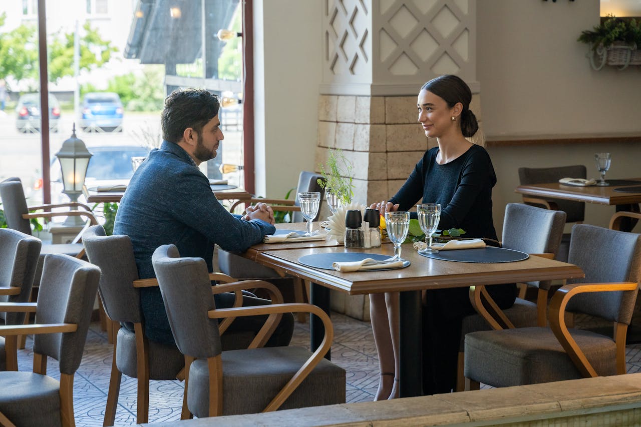 services-02 A man and woman enjoying a romantic meal in a cozy café setting, exuding warmth and connection.